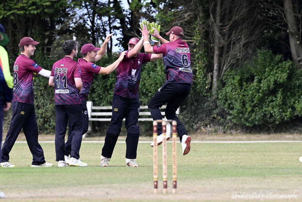 Wadebridge players in club maroon celebrating a wicket.